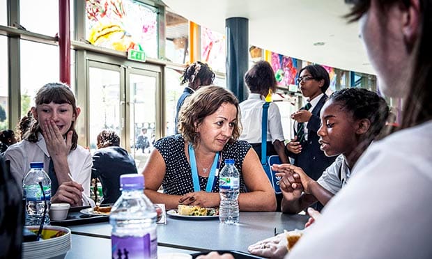 Headteacher Miss Smith talking to Alexandra at lunch time in the dinner hall